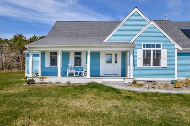 view of front of house with a front lawn, covered porch, and a shingled roof