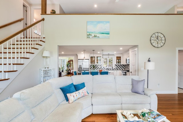 living area with stairs, recessed lighting, and wood finished floors