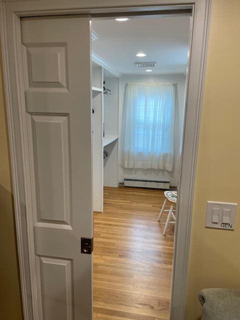 hall featuring a baseboard radiator and light hardwood / wood-style flooring