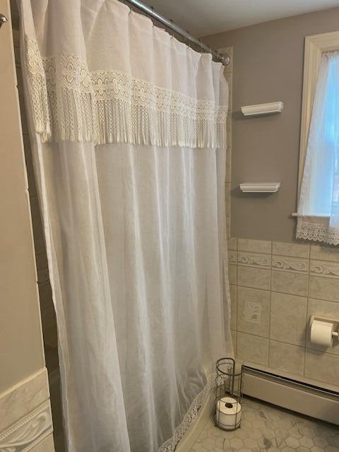 bathroom featuring tile walls and baseboard heating