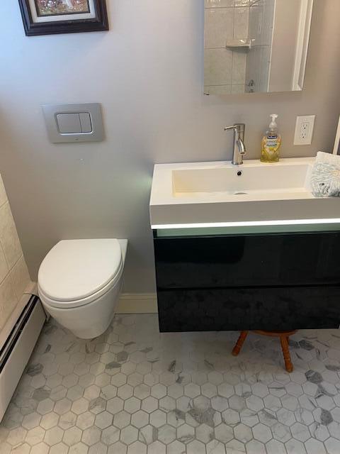 bathroom with vanity, toilet, and baseboard heating