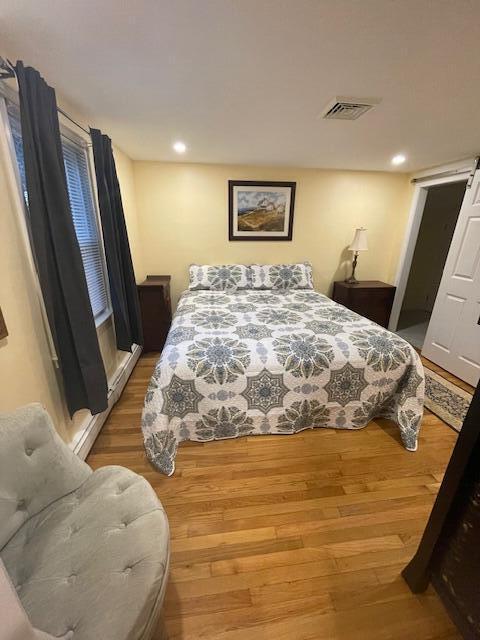 bedroom with hardwood / wood-style flooring and a barn door