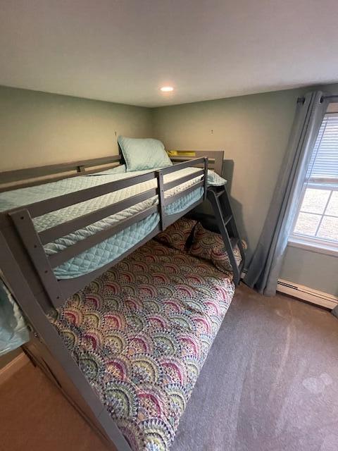 carpeted bedroom with a baseboard heating unit