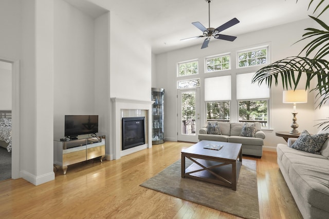 21 Grey Hawk Dr, Mashpee, MA 02649 - living area featuring a high ceiling, ceiling fan, a tile fireplace, wood finished floors, and baseboards