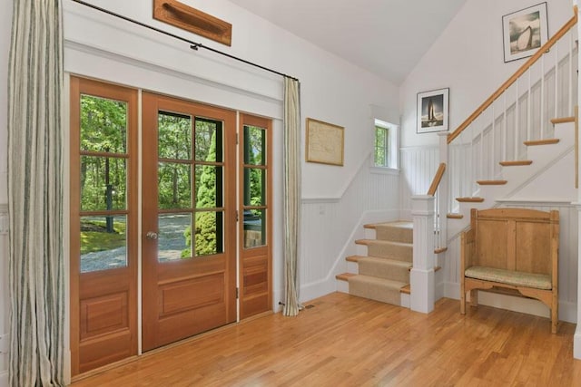 14 Indian Trl, Osterville, MA 02655 - foyer featuring stairway, vaulted ceiling, a wainscoted wall, light wood-style flooring, and a decorative wall