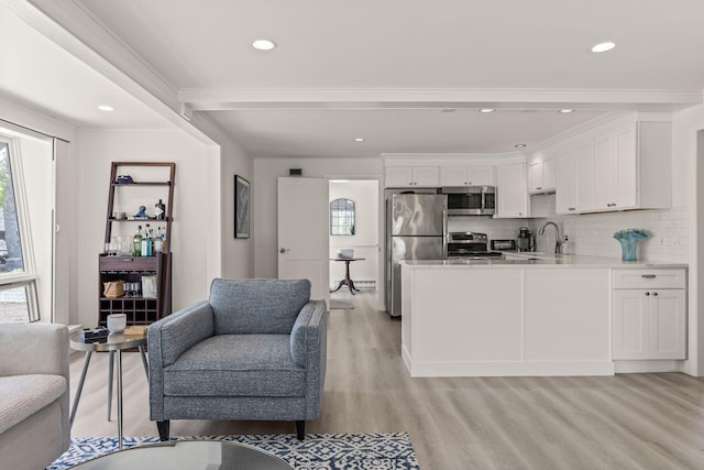 living room featuring healthy amount of natural light, light wood finished floors, recessed lighting, and crown molding