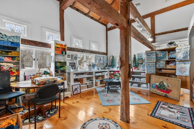 office area featuring wood-type flooring, beamed ceiling, and a high ceiling