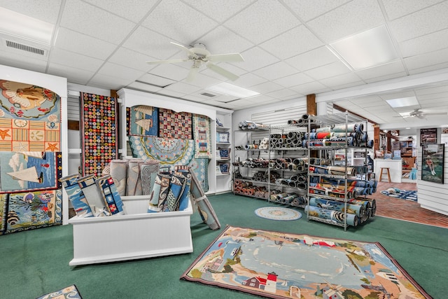 misc room featuring carpet floors, a paneled ceiling, and ceiling fan