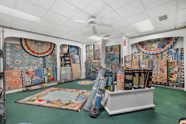 rec room with ceiling fan, a paneled ceiling, and carpet floors