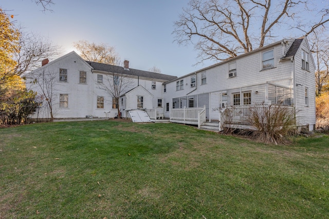 back of house featuring a wooden deck and a lawn