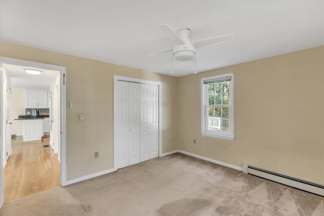 unfurnished bedroom with a closet, ceiling fan, light colored carpet, and a baseboard radiator