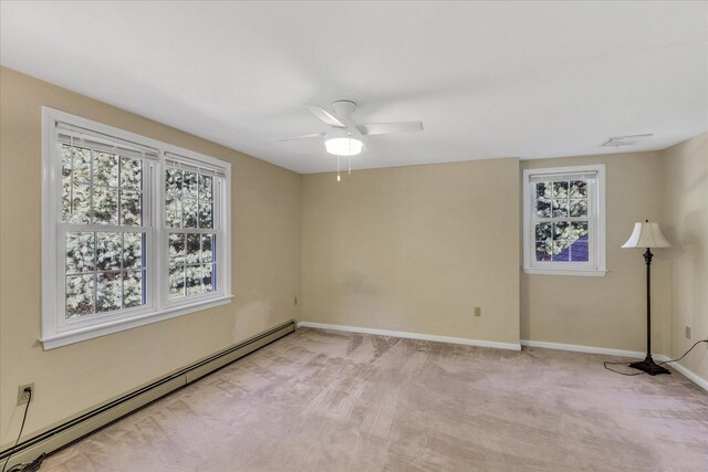 carpeted spare room with ceiling fan and a baseboard heating unit