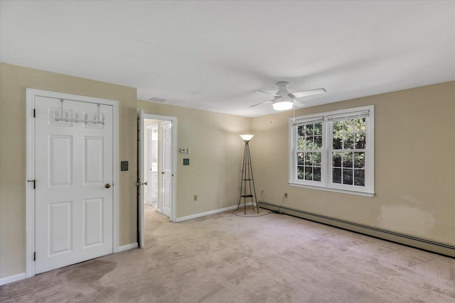 carpeted empty room featuring ceiling fan and a baseboard heating unit