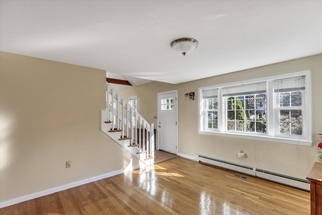 foyer featuring baseboard heating and light hardwood / wood-style flooring