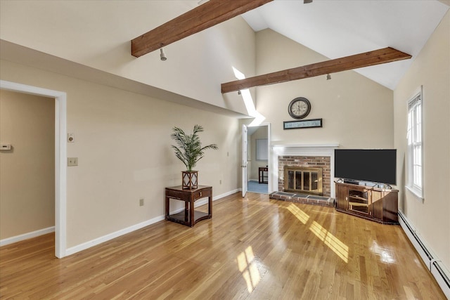 living room featuring a brick fireplace, lofted ceiling with beams, light hardwood / wood-style flooring, and a baseboard heating unit