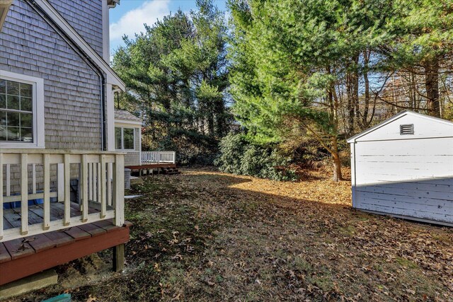 view of yard with a shed and a wooden deck