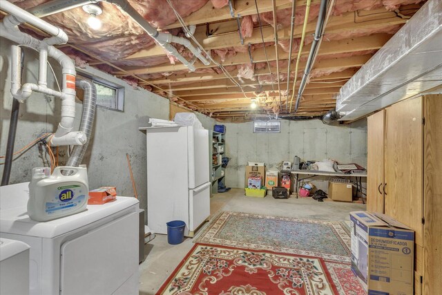 basement featuring white fridge and washer and dryer