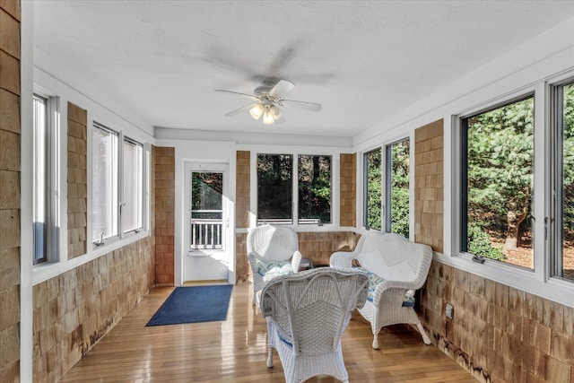 sunroom featuring ceiling fan and plenty of natural light