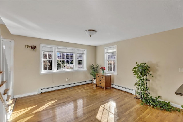 empty room with wood-type flooring and a baseboard radiator