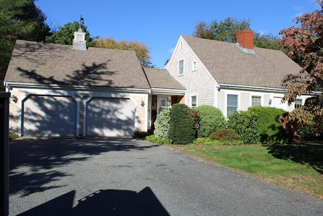 cape cod home featuring a garage