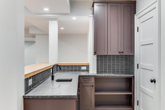 kitchen with recessed lighting, a sink, open shelves, and decorative backsplash