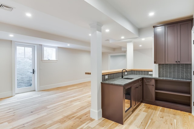 kitchen featuring visible vents, baseboards, light wood finished floors, and stone countertops