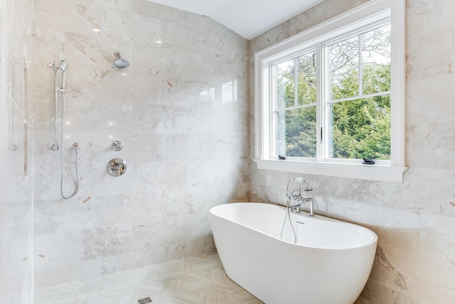 full bathroom with tile walls, tiled shower, and a freestanding tub