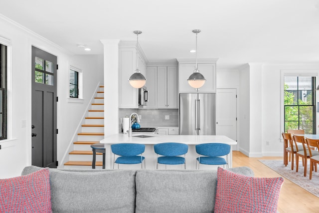 350 Bradford St Unit U5, Provincetown, MA 02657 - kitchen with high quality fridge, a sink, light countertops, light wood-style flooring, and backsplash