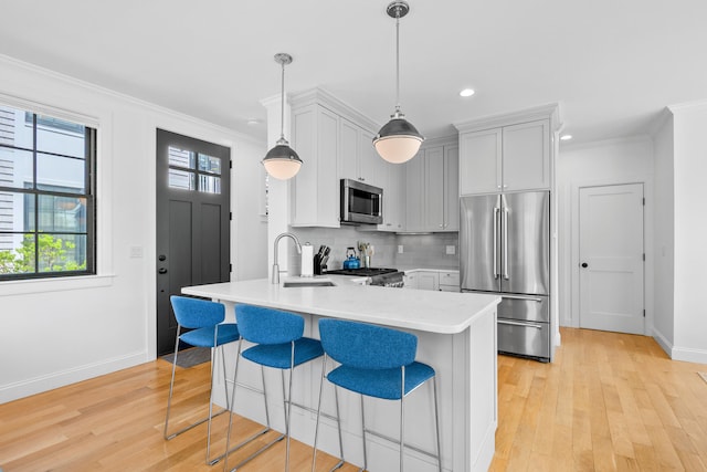 350 Bradford St Unit U5, Provincetown, MA 02657 - kitchen featuring stainless steel appliances, a sink, light countertops, baseboards, and a kitchen breakfast bar