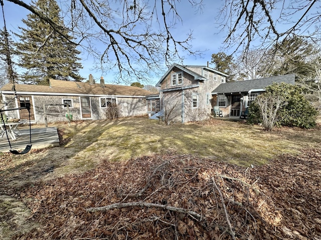 rear view of property with a yard and a chimney