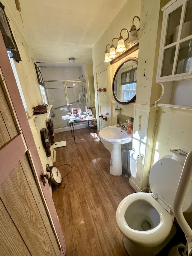 full bathroom with wood finished floors and a shower stall