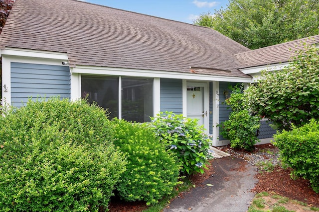 87 Susanna Dr, Brewster, MA 02631 - view of exterior entry featuring roof with shingles and a surveillance system