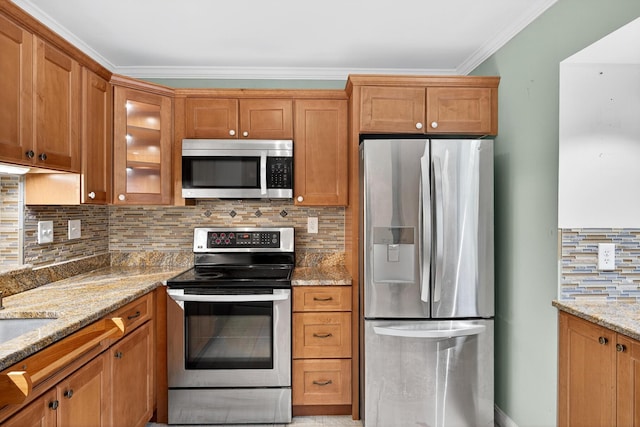 87 Susanna Dr, Brewster, MA 02631 - kitchen featuring appliances with stainless steel finishes, brown cabinetry, light stone counters, and ornamental molding
