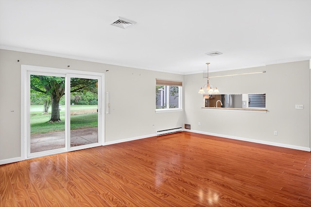 87 Susanna Dr, Brewster, MA 02631 - spare room with a chandelier, wood finished floors, baseboard heating, healthy amount of natural light, and crown molding