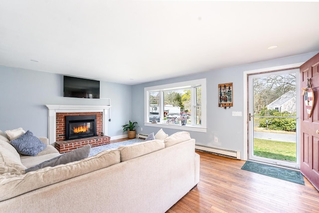 1 Stevens Way, Harwich, MA 02645 - living room with a baseboard radiator, a wealth of natural light, light wood-style flooring, and a brick fireplace
