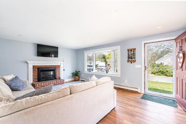 1 Stevens Way, Harwich, MA 02645 - living room featuring a baseboard radiator, light wood-style flooring, a baseboard heating unit, and a brick fireplace