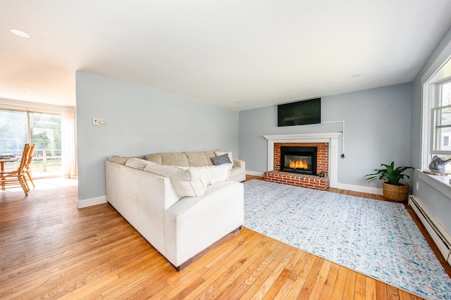 1 Stevens Way, Harwich, MA 02645 - living room with a brick fireplace, baseboards, baseboard heating, and light wood-type flooring