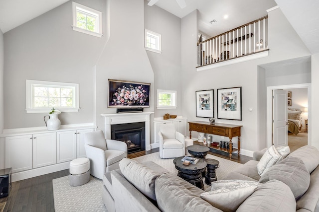 41 Old Main Rd Unit 3Au, North Falmouth, MA 02556 - living area with a towering ceiling, dark wood-style floors, a glass covered fireplace, and healthy amount of natural light