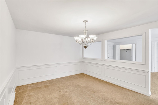 unfurnished room with light carpet and a notable chandelier