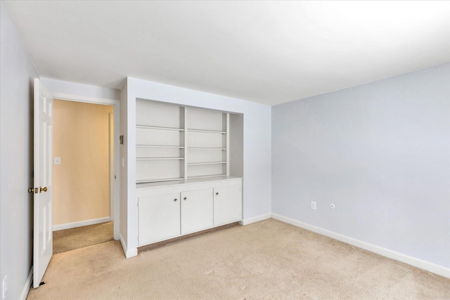 unfurnished bedroom featuring light carpet and a closet