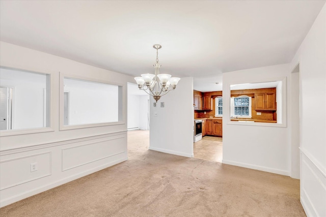 unfurnished dining area featuring an inviting chandelier and light carpet