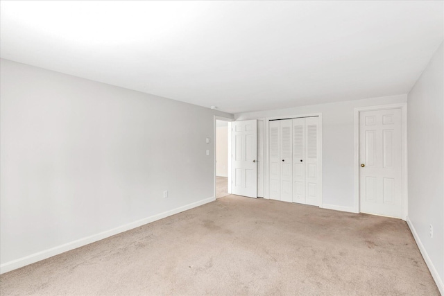 unfurnished bedroom featuring a closet and light carpet