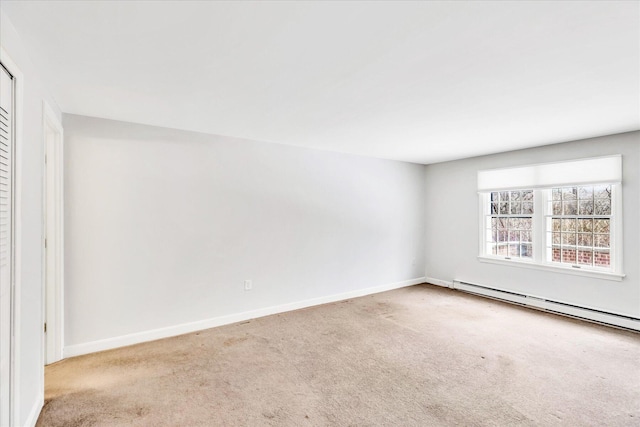 spare room featuring a baseboard radiator and light carpet