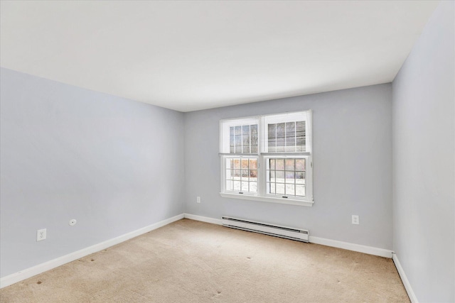 carpeted spare room with a baseboard heating unit