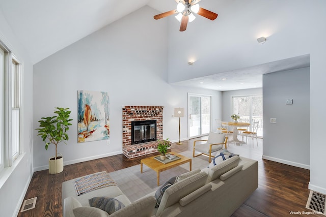 living area with visible vents, baseboards, wood finished floors, and a fireplace