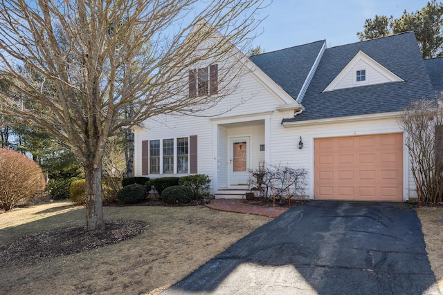 view of front of house featuring a garage, a shingled roof, and aphalt driveway