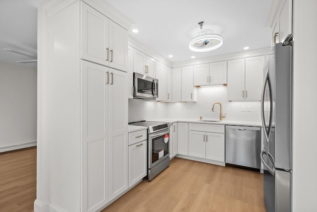 kitchen featuring a sink, light wood-style floors, stainless steel appliances, recessed lighting, and white cabinetry