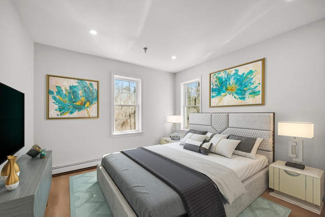 bedroom with recessed lighting, wood finished floors, and baseboard heating