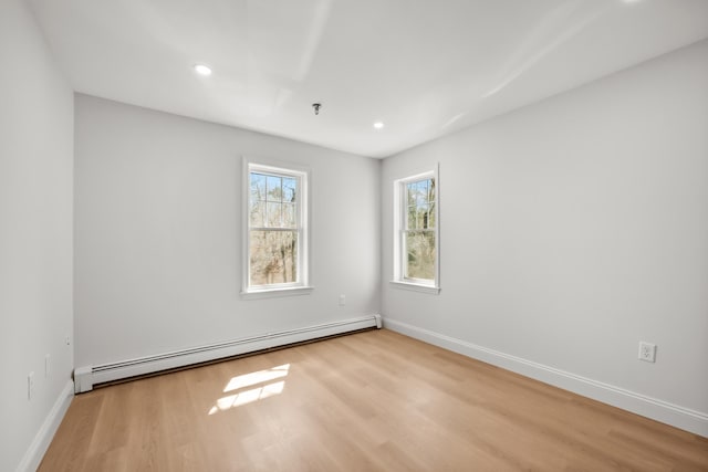 empty room featuring recessed lighting, baseboards, wood finished floors, and baseboard heating
