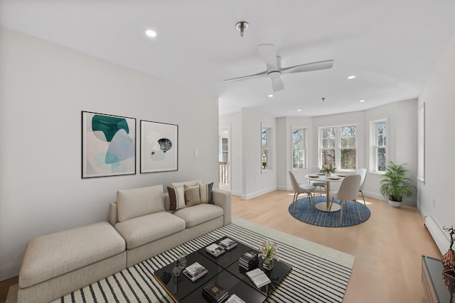 living room featuring a ceiling fan, baseboards, recessed lighting, and wood finished floors